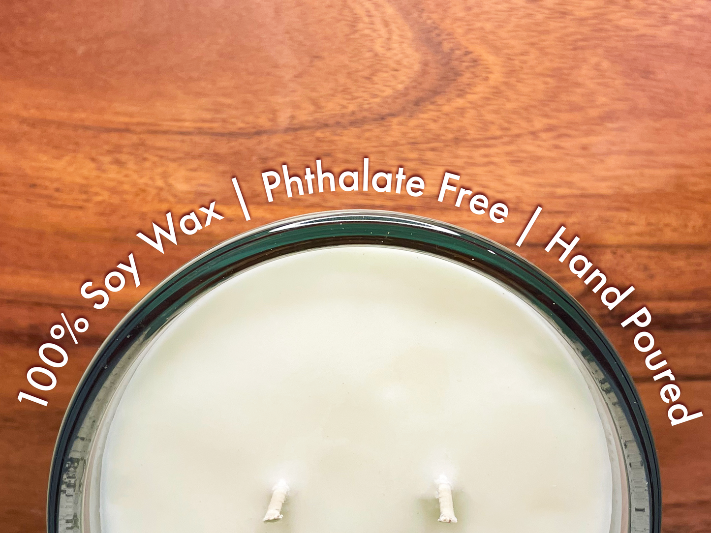 top view of a candle halfway off the photo with the words wrapped around the candle 100% soy wax, phthalate free, hand poured with a wood grain background.
