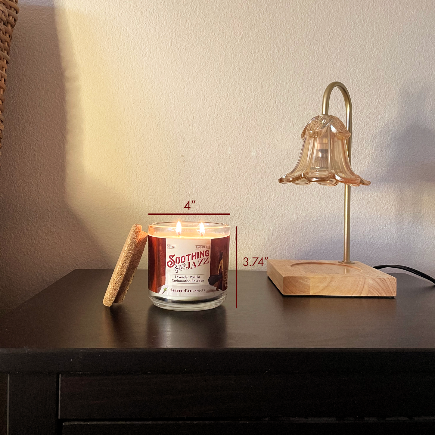 Bed scene with a lit candle on a nightstand next to a lamp. There are dimensions over the candle 4 inches by 3.74 inches